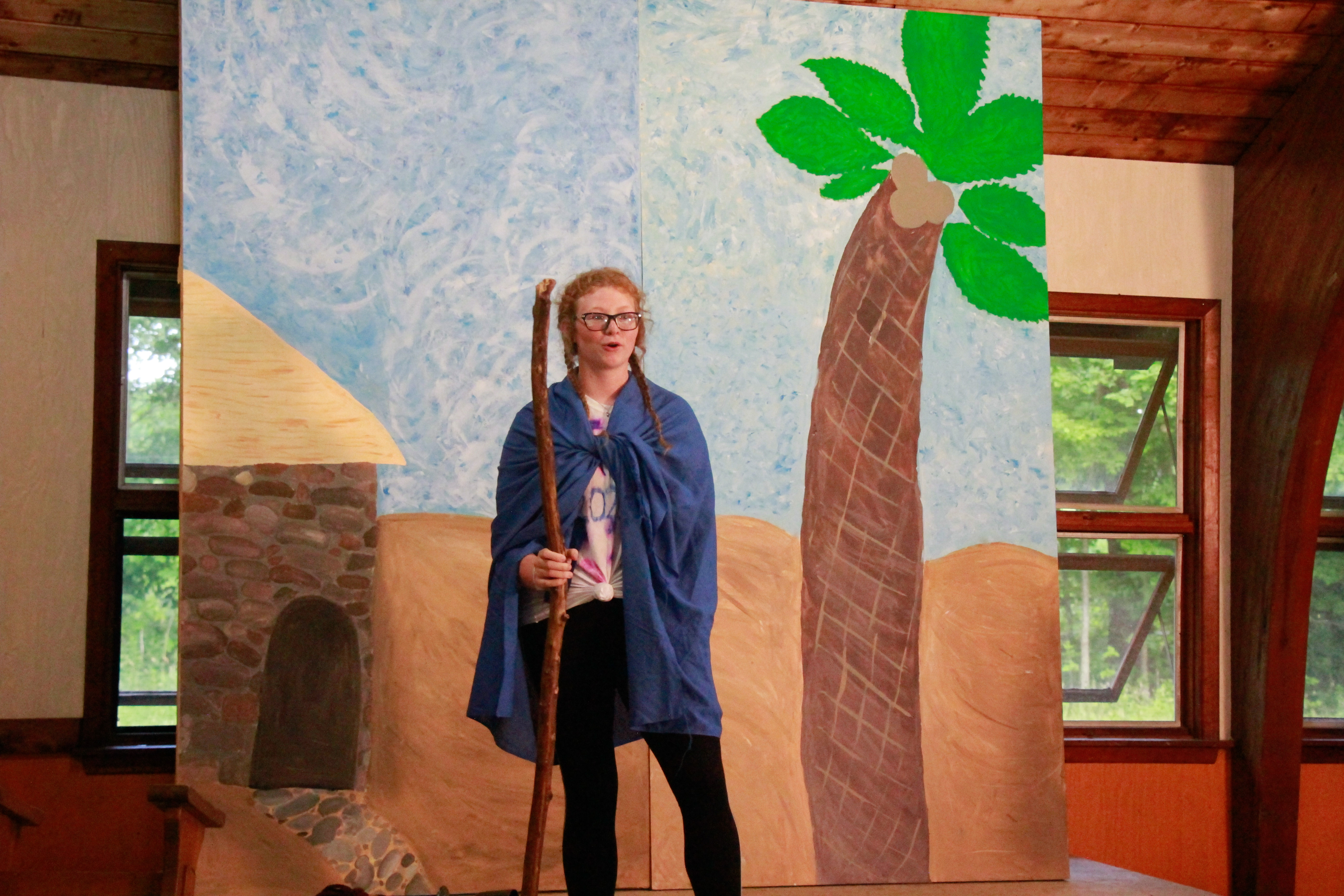 Camper in costume on stage with a backdrop.